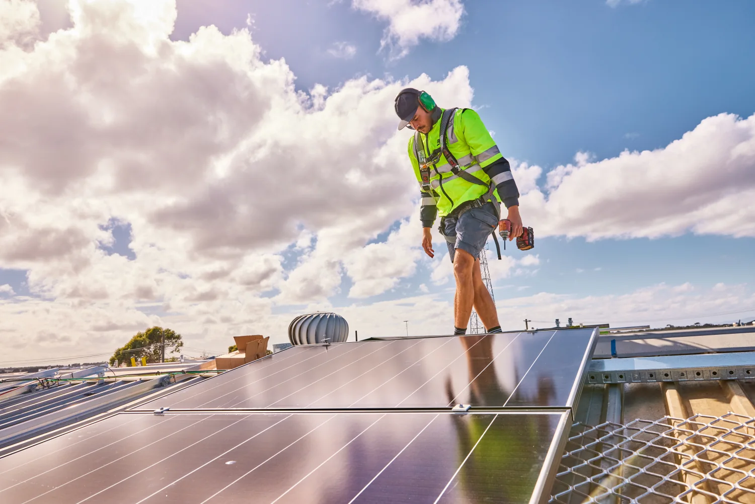 Solar installer working on rooftop solar panels